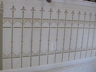 Stenciled art work on half wall in living room